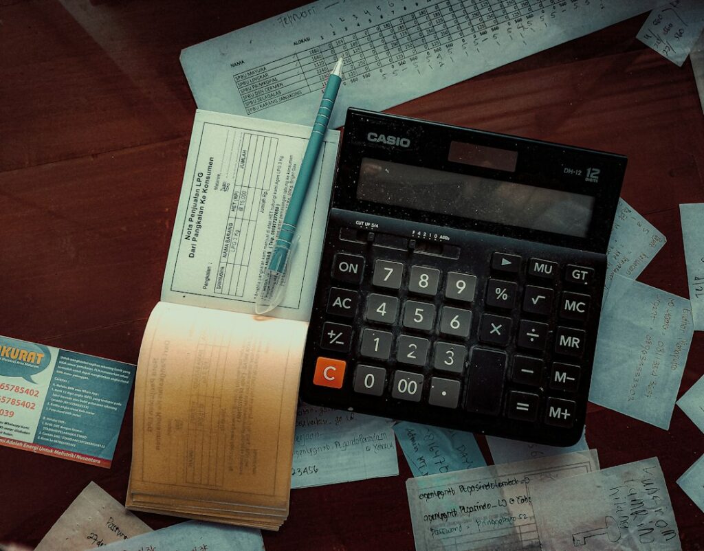 A couple reviews tax forms, donation receipts, and mortgage records at a kitchen table.