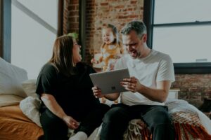 A couple reviews tax forms and household expense records at a kitchen table.