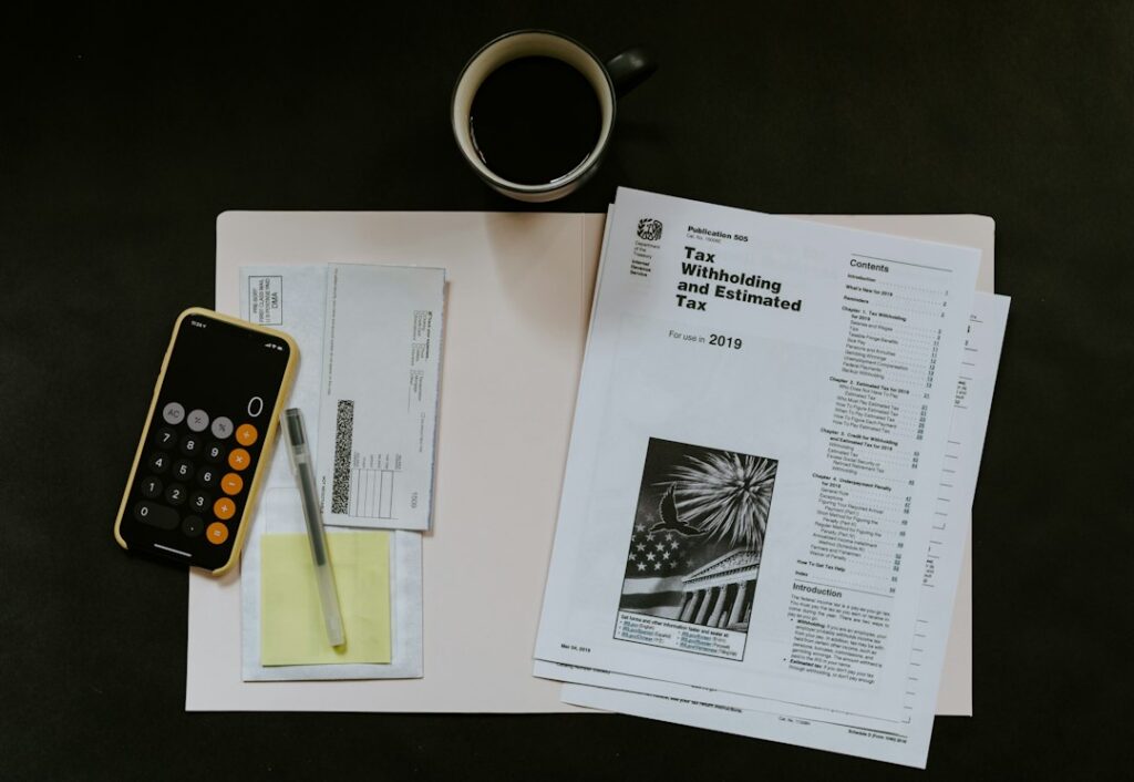 Person organizing receipts, mileage logs, donation records, and tax forms on a home table.